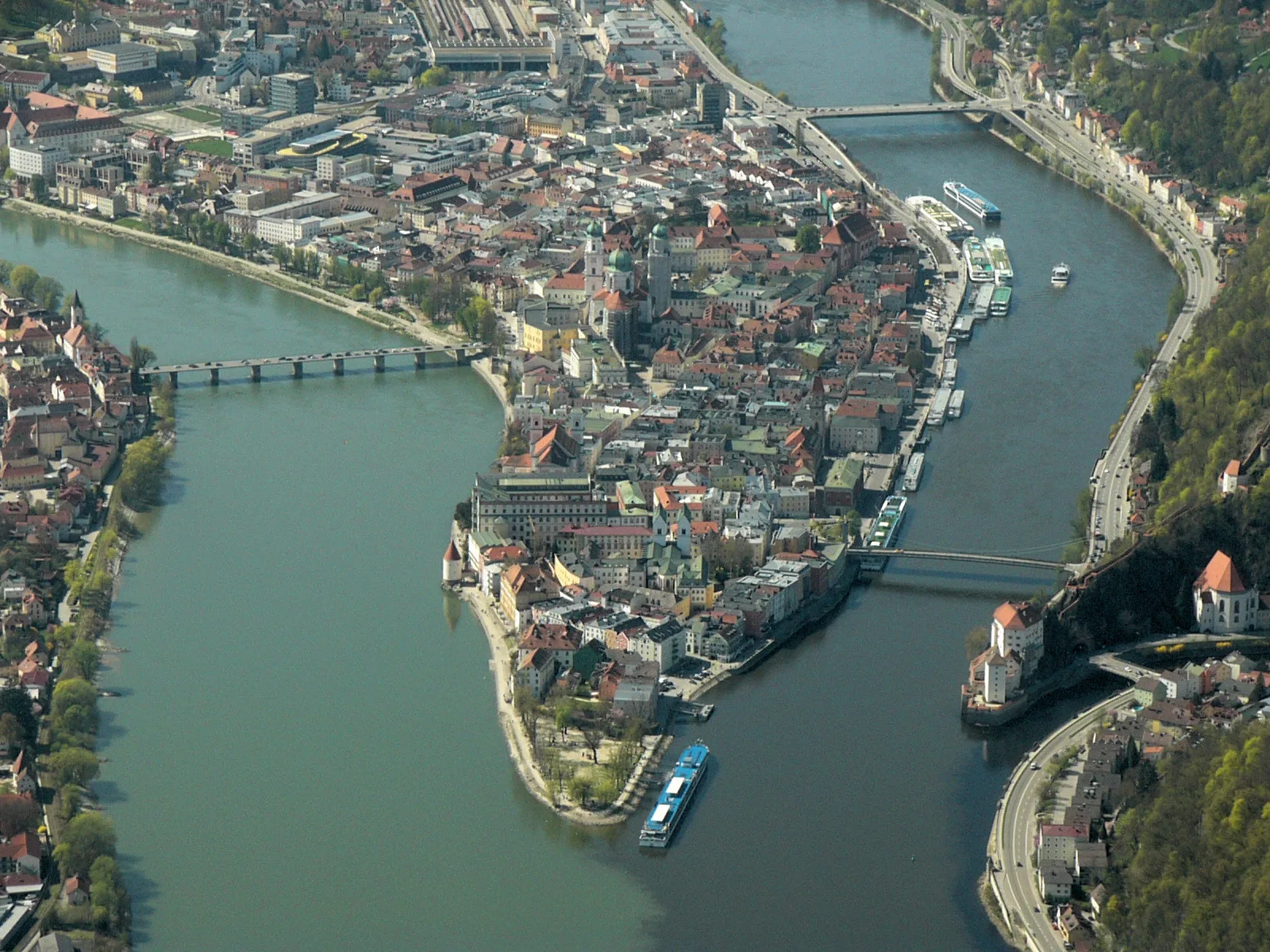 An aerial view of the old town of Passau on its peninsula between the Danube and the Inn, with river vessels at the quay.