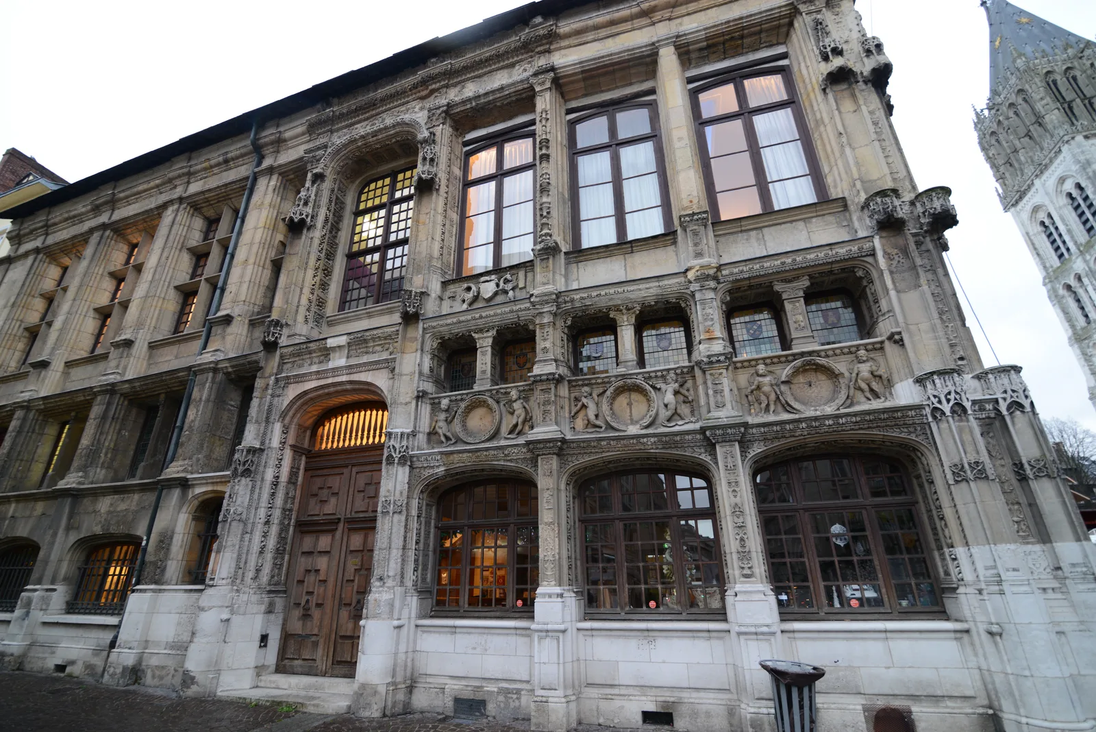 A richly carved stone facade at a street corner in the old town of Rouen.