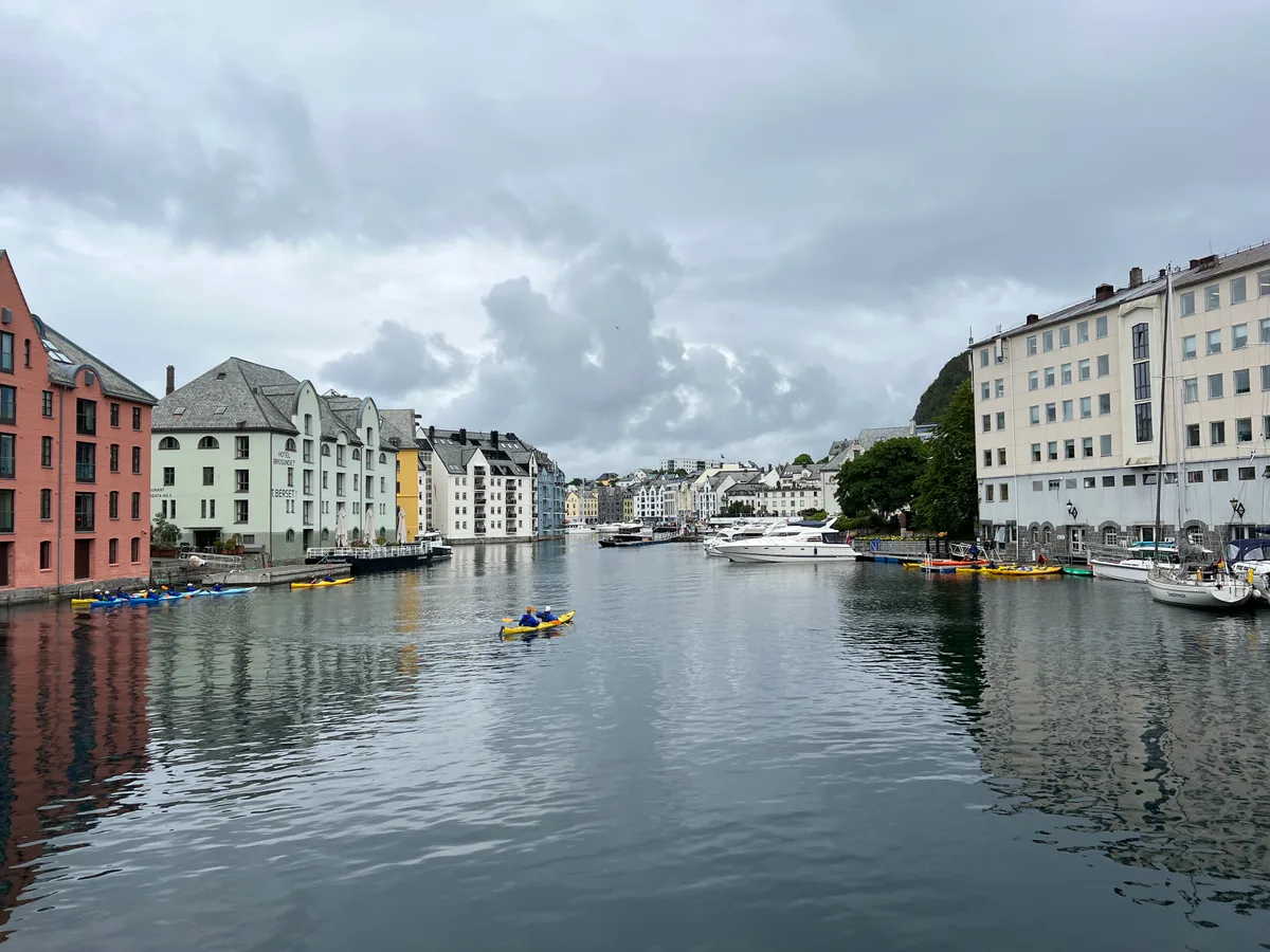 Colourful Art Nouveau buildings reflected in the still Alesundet canal in Alesund.