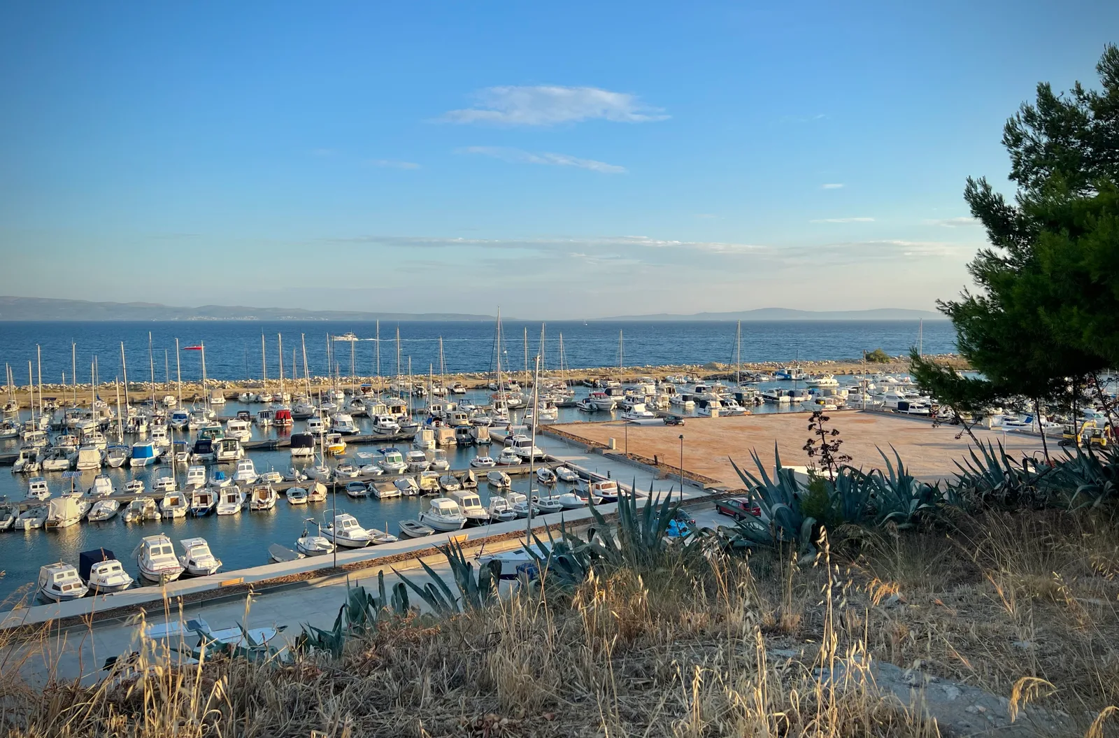 Hundreds of small boats moored in Lucica harbour beside Marina Zenta with the open sea behind.