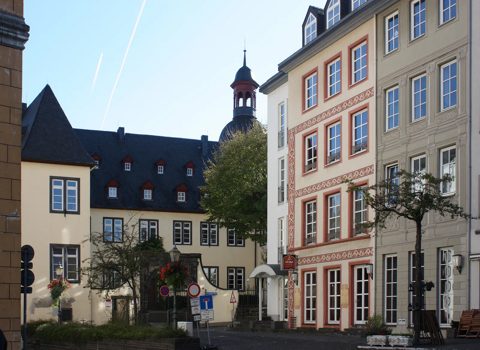 Pastel old-town buildings and a courtyard gable on the Florinsmarkt in Koblenz on a clear day.