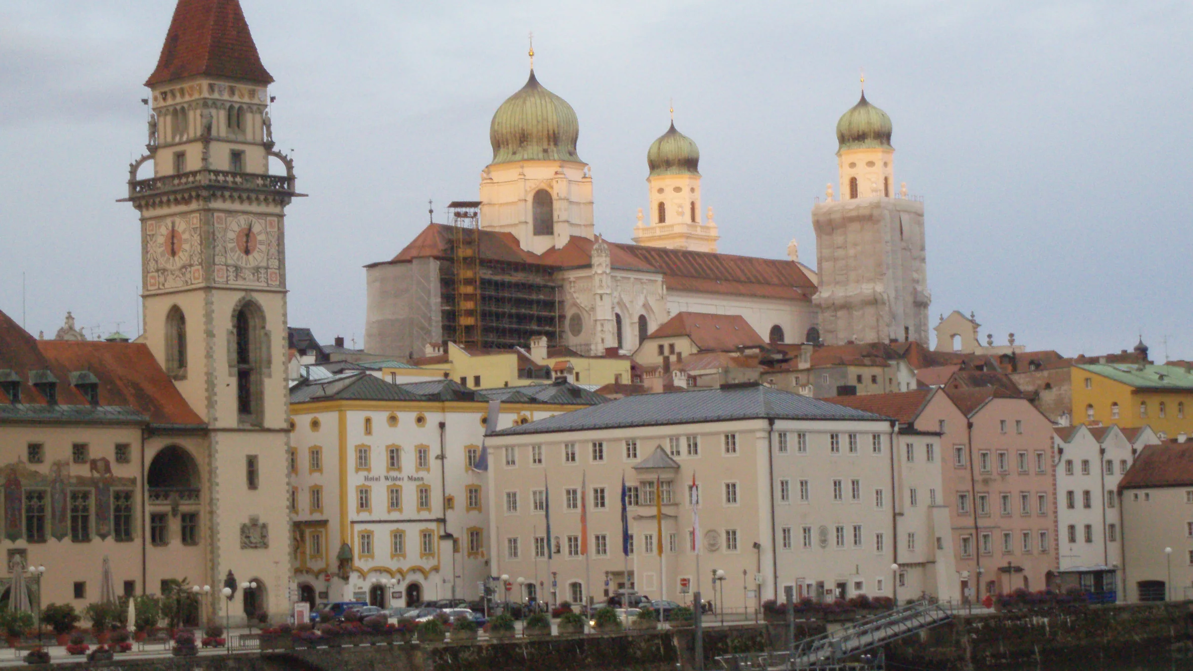 The old town of Passau on the Inn with the town hall tower and the cathedral's green domes, reflected in the river.