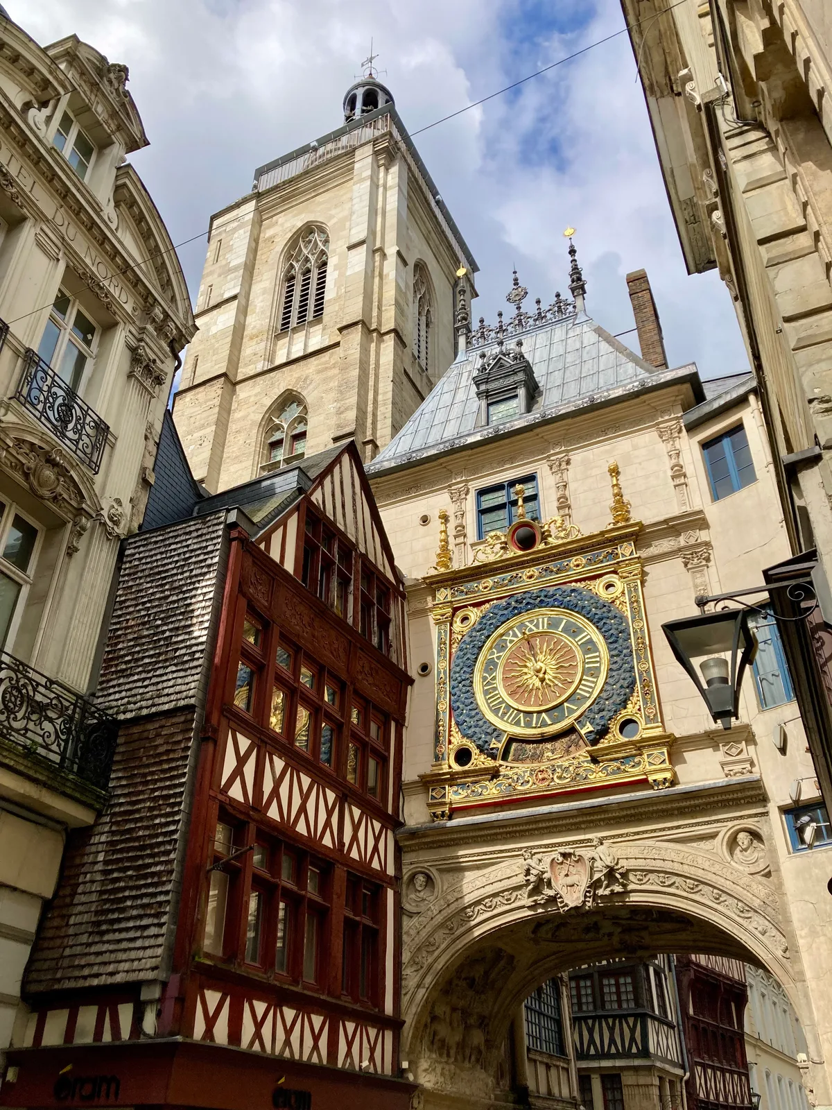 The Gros-Horloge astronomical clock arch and belfry in Rouen between half-timbered houses.