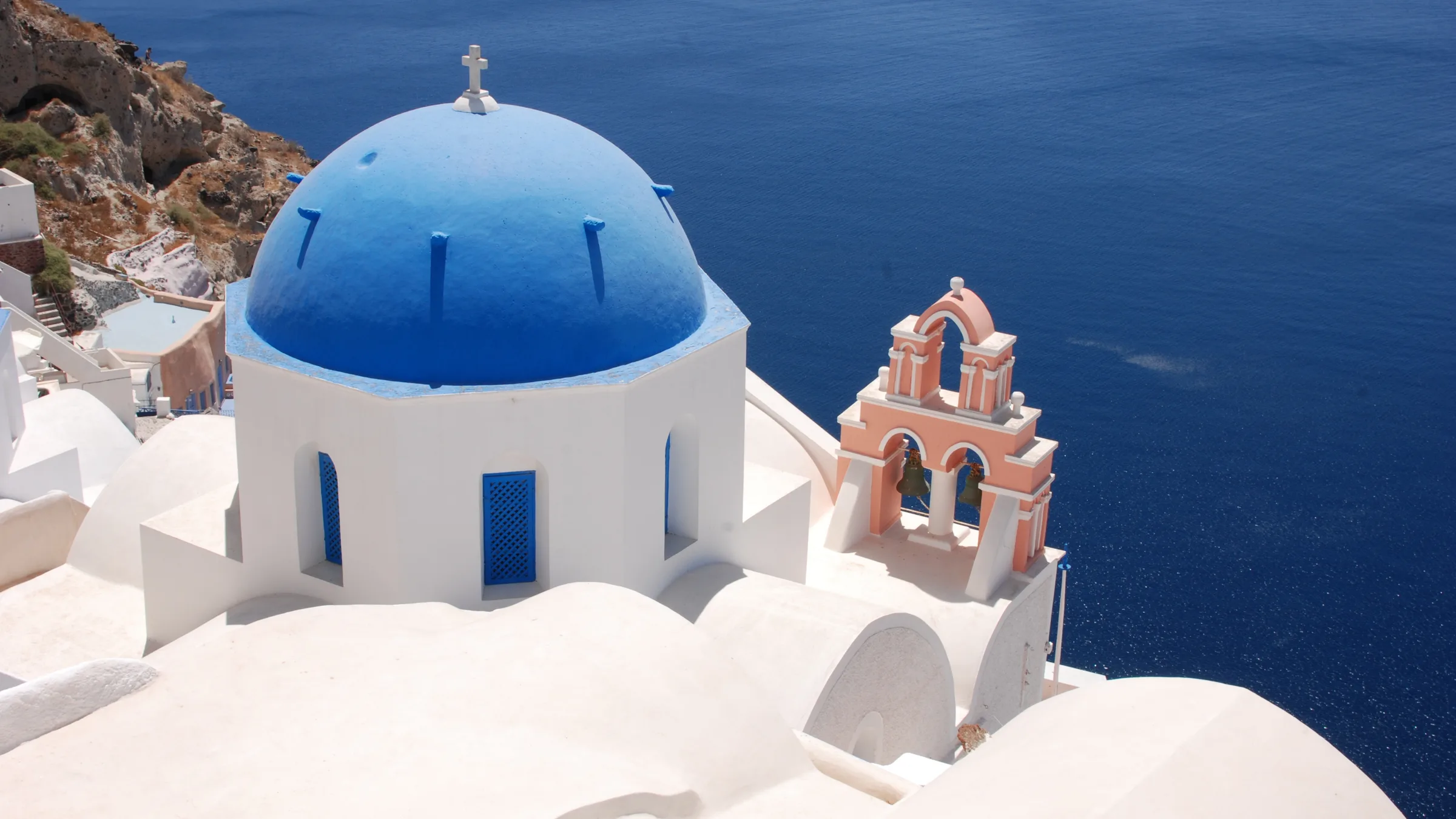 The blue-domed church of Oia in Santorini overlooking the caldera at golden hour
