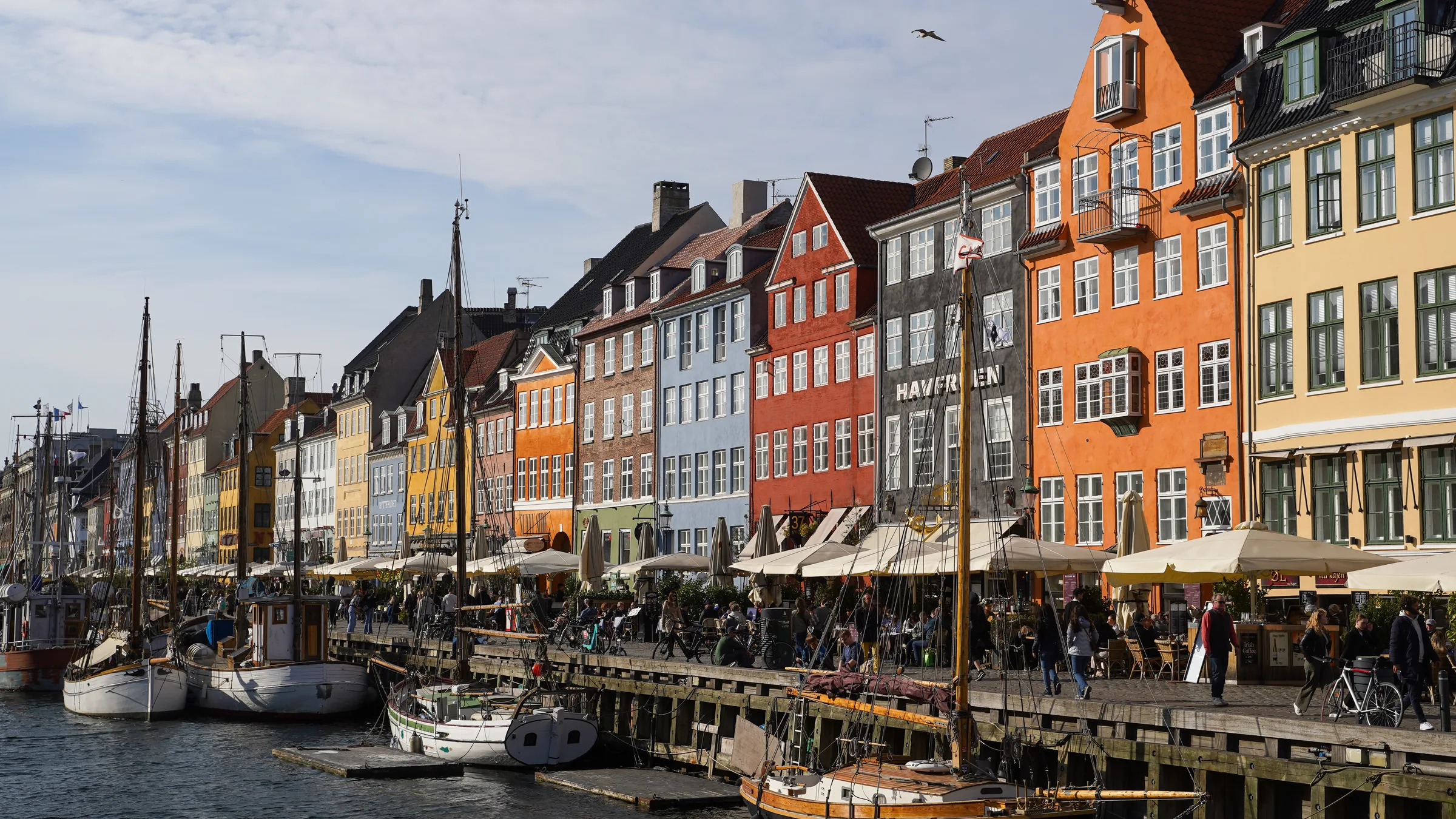 Colourful gabled houses and old wooden boats along the Nyhavn canal in Copenhagen.