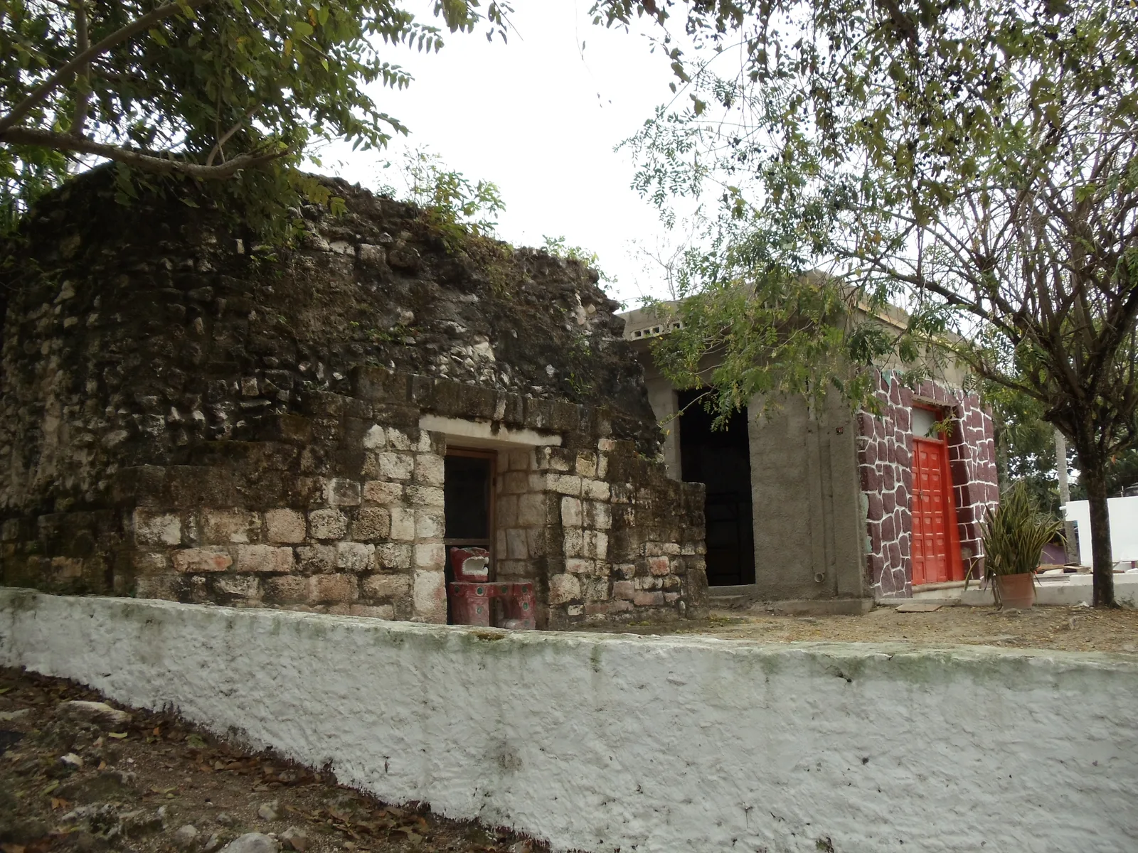 A small ancient stone Maya building and a Catholic church side by side at El Cedral on Cozumel.