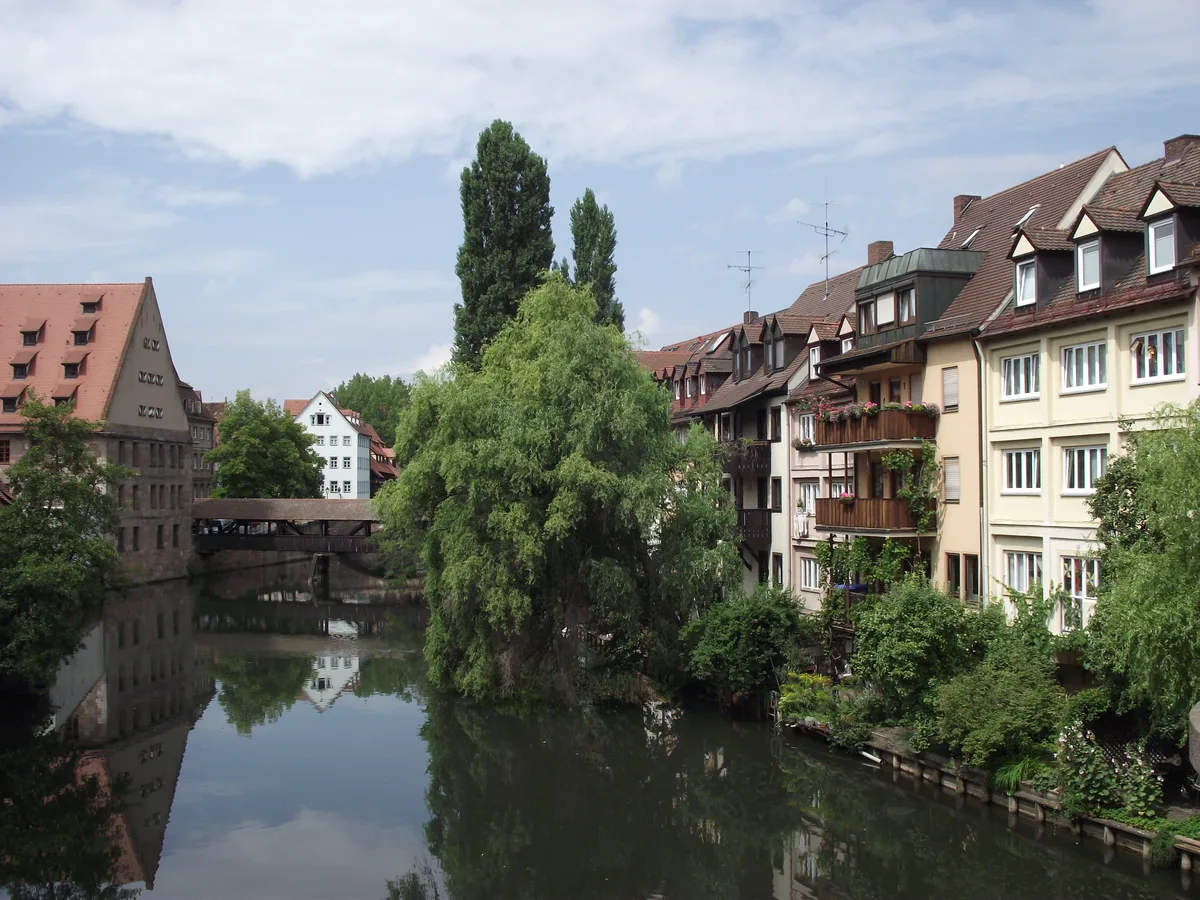 The Pegnitz river in Nuremberg with half-timbered houses and willow trees along the bank.