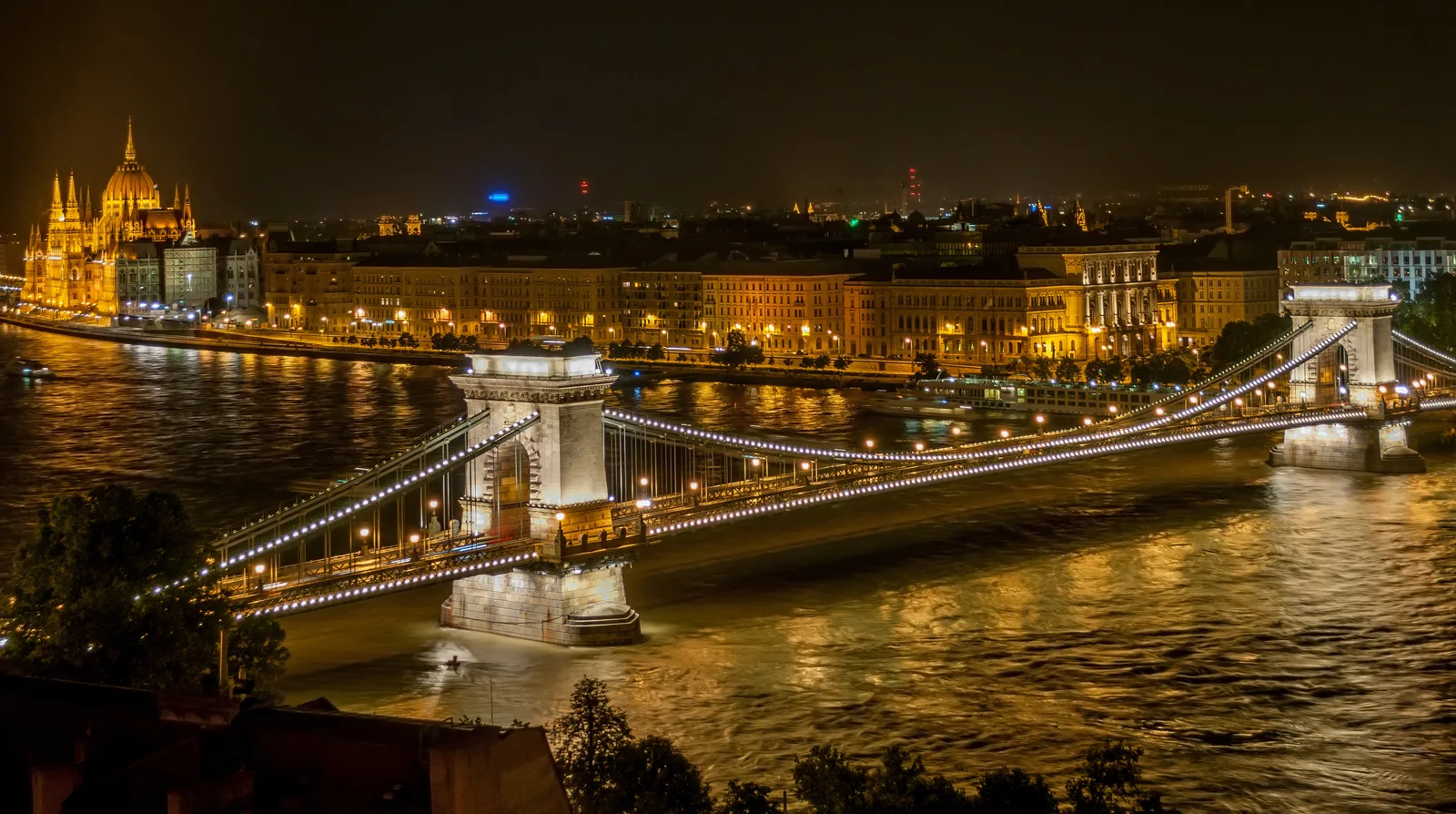 The Széchenyi Chain Bridge lit at night over the Danube.