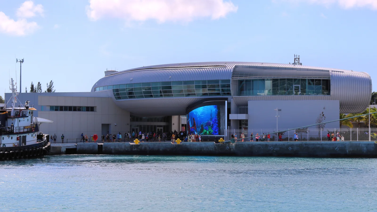 The modern curved Nassau cruise port terminal building beside the harbour water.