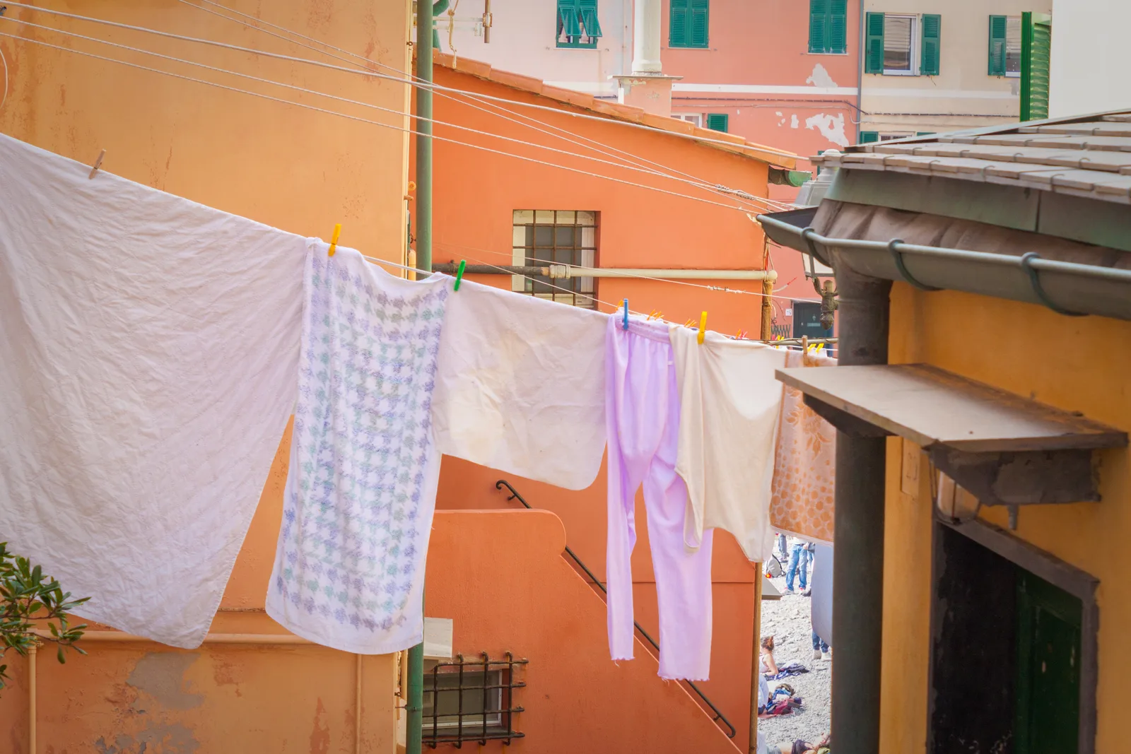 Laundry hanging in the sun over a pastel Boccadasse lane in Genoa.