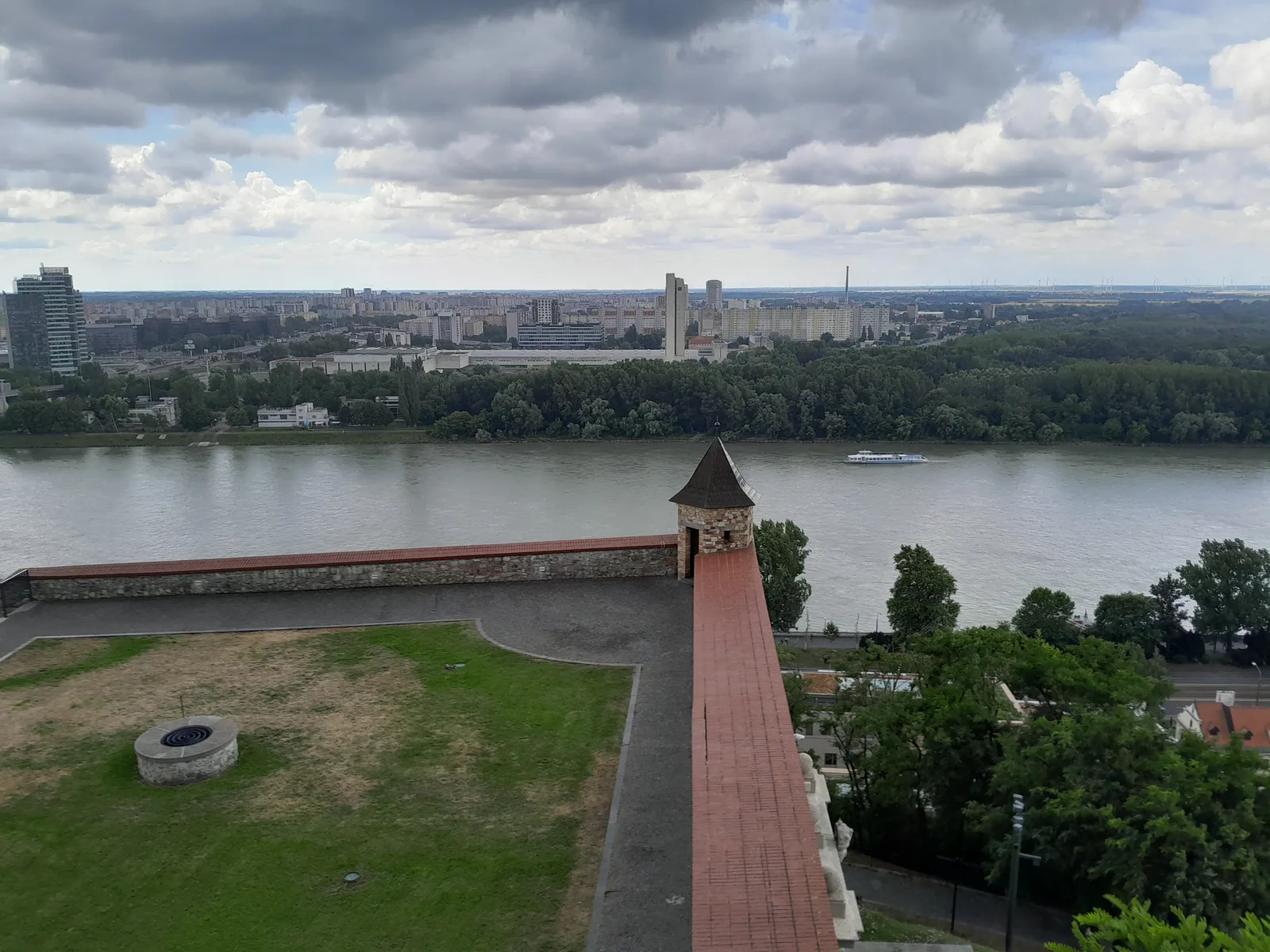 The Danube flowing below the castle bastion walls, with a bridge and the city beyond.