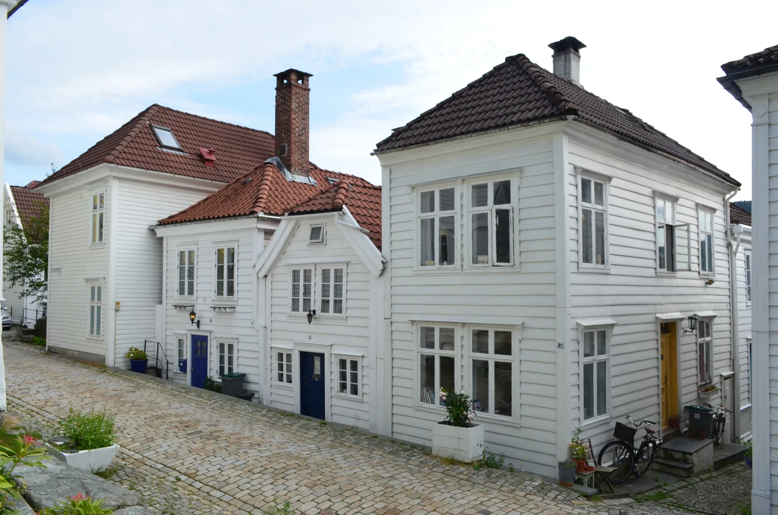 White timber houses on a cobbled Nordnes street in Bergen.