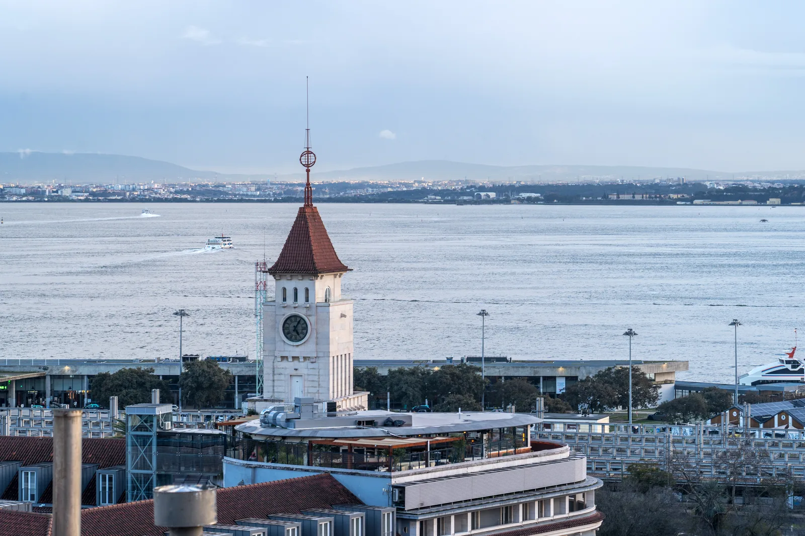 A view of the Tagus and the harbour from a Lisbon viewpoint with a clock tower on the quay.