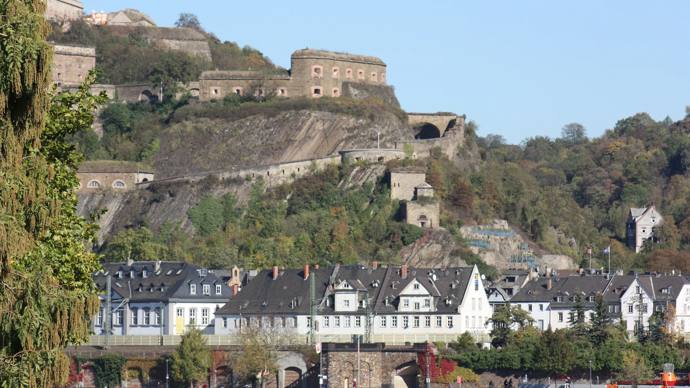 The fortress of Ehrenbreitstein above the Rhine bank and a row of slate-roofed houses opposite Koblenz.