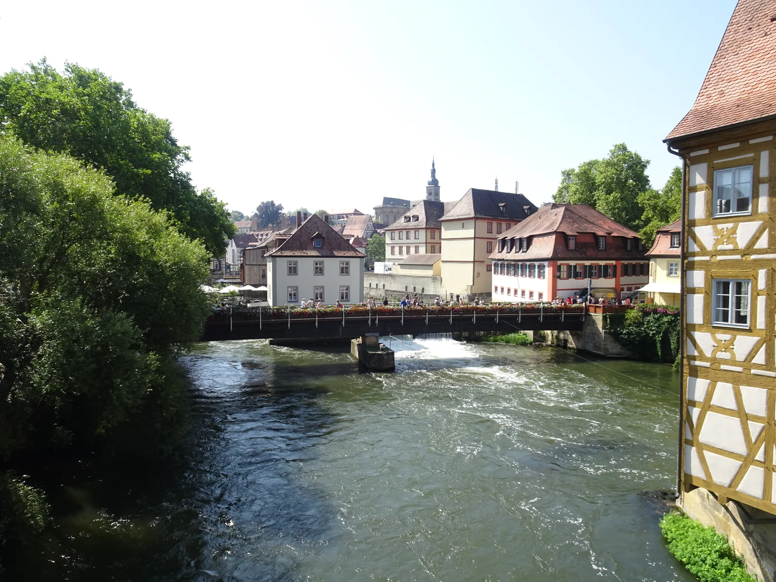 The Regnitz weir in Bamberg with the half-timbered corner of a building at the right edge.