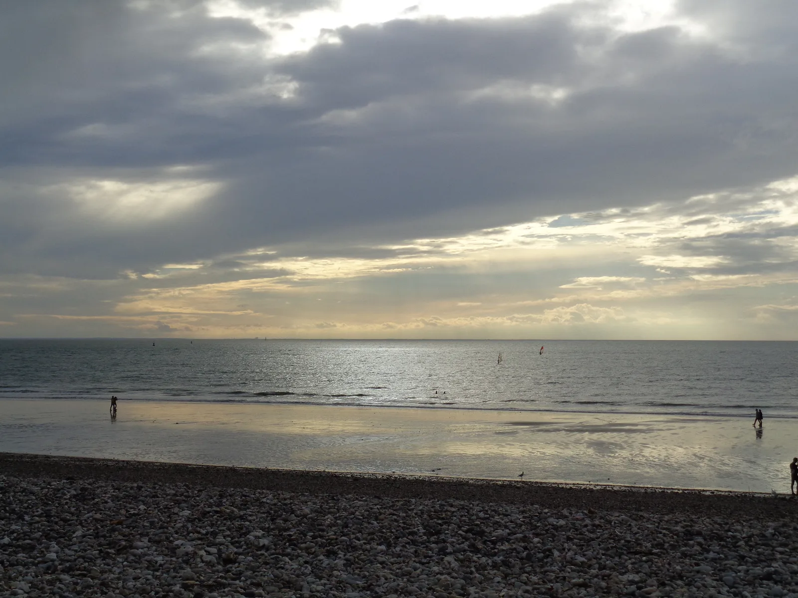 Early evening light on the sea and wet sand at Le Havre with tiny distant walkers.