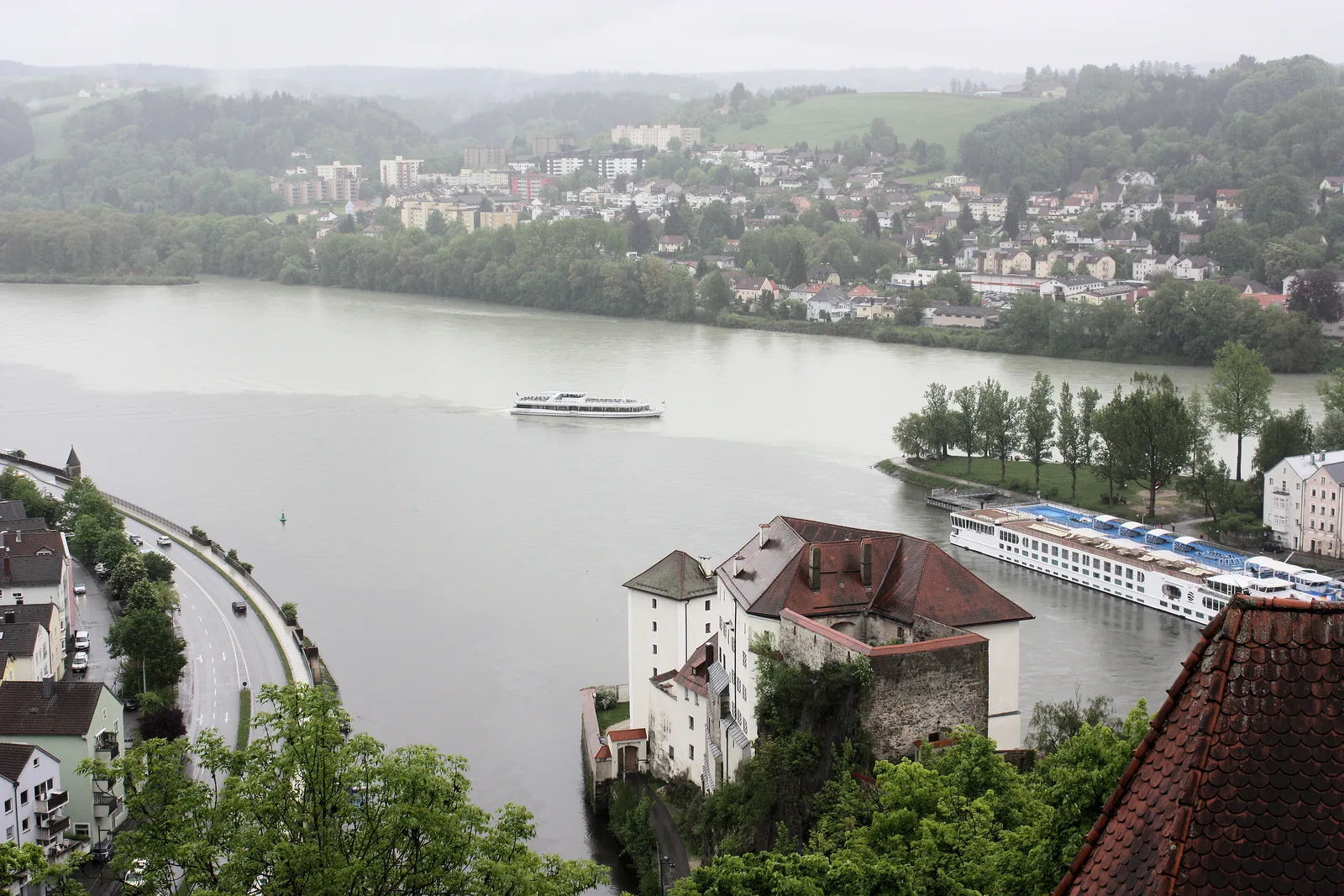 The Niederhaus fortress and the Danube from the Oberhaus fortress in Passau, with a river ship moored at the point where the rivers meet.